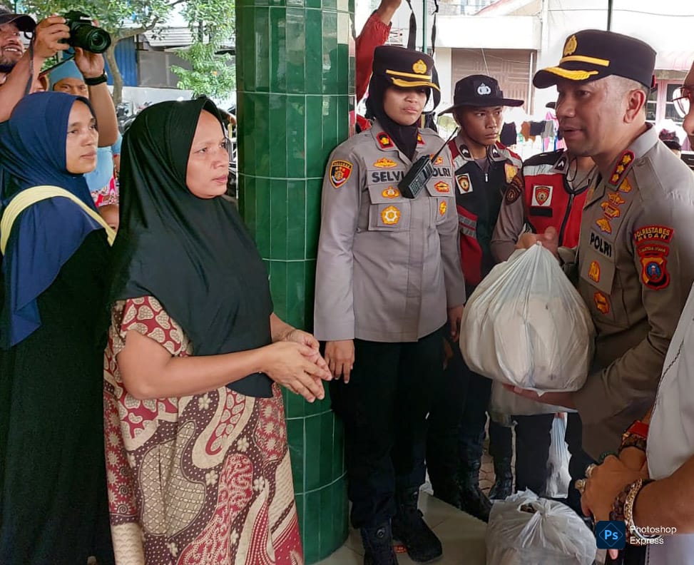 Kombes Pol Dr Jean Calvijn Simanjuntak menyerahkan bantuan pada korban banjir di Kelurahan Hamdan. (Restabes Medan Dok)